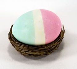 Tri-colored striped Easter egg in a nest.